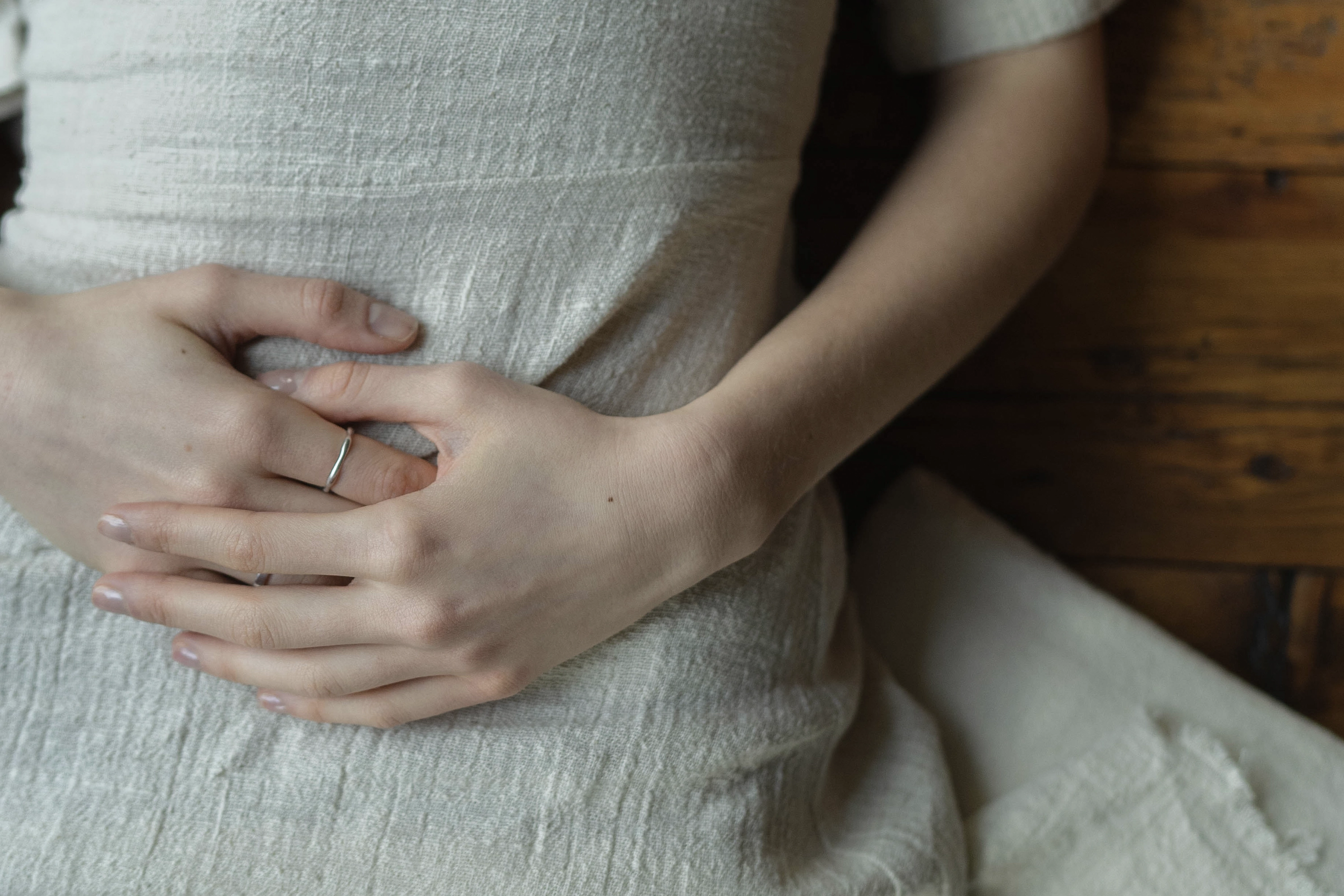 person lying on ground with hands on stomach 